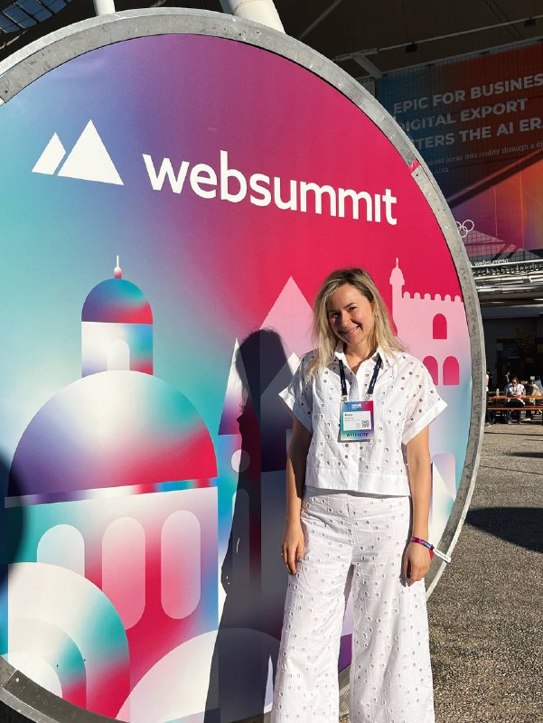 Анна Стрижова у баннера Web Summit в Лиссабоне — фотография с технологической конференции, иллюстрирующая участие IBC.