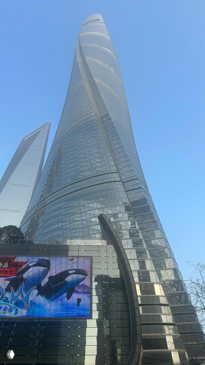 Высотное здание Shanghai Tower, снятое снизу на фоне чистого голубого неба, современный городской пейзаж Пудуна.