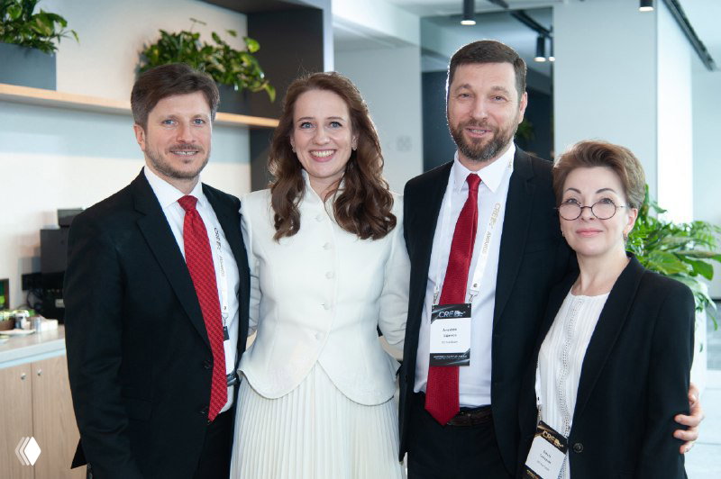 Команда IBC Real Estate в деловой одежде на CRE Moscow Awards 2025: четверо сотрудников улыбаются на фоне офиса.
