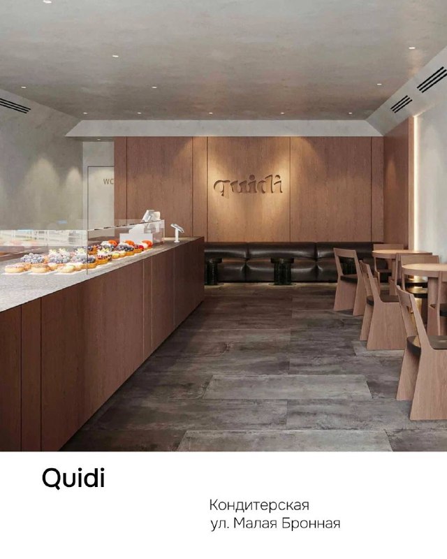 Интерьер кондитерской Quidi: лаконичный зал с витриной десертов, деревянные столы и спокойная палитра в центре Москвы.