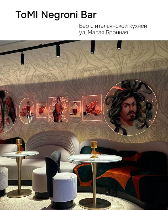 Интерьер бара ToMI Negroni Bar: уютные диваны, украшенные картины на стенах и барная стойка в тёплой цветовой гамме.