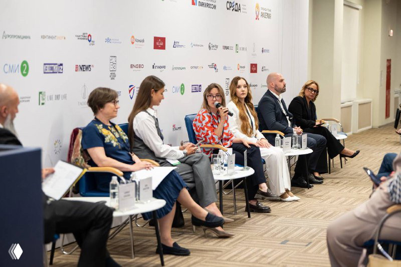 Панельная дискуссия: несколько экспертов сидят в ряд на сцене перед аудиторией и обсуждают вопросы земельных активов и инвестиций