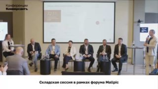Панельная дискуссия Mallpic Sochi: несколько спикеров на сцене перед большим экраном, видна сцена и часть аудитории в зале