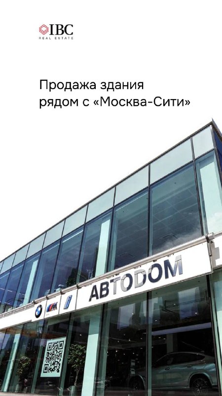 Фасад отдельно стоящего современного здания рядом с Москва‑Сити: витринное остекление и вывеска автосервиса, внешний вид и входная зона объекта.