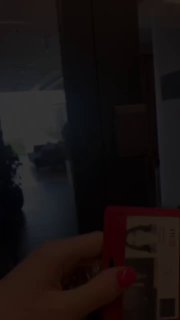 Кадр из офисного видео IBC Real Estate: коридор офиса на заднем плане, в переднем плане рука держит красный бейдж‑пропуск.