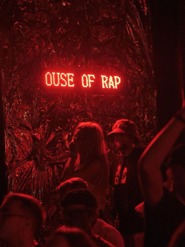 Неоновая красная вывеска «OUSE OF RAP» и силуэты людей на фоне — энергичная клубная сцена, ассоциируется с тусовочной атмосферой Union.