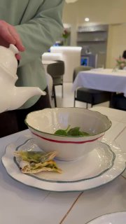 Рука наливает горячий чай в пиалу в интерьере Lamponi: тихая семейная атмосфера, сервировка и посуда крупным планом.