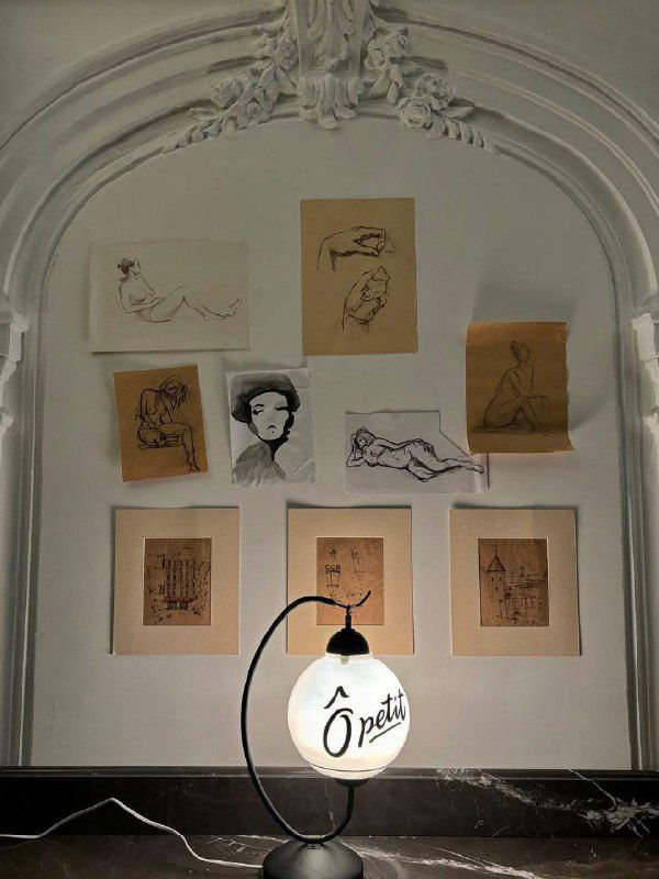 Стеновая композиция с рисунками и лампой-логотипом одного из пространств внутри особняка — элементы экспозиции и оформления стен.