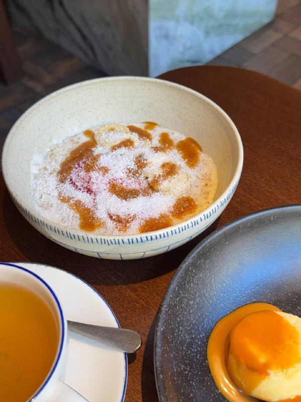 Овсяная каша с мисо-карамелью и бананом: кремовая подача в миске с карамельными разводами и ломтиками банана, крупный план.