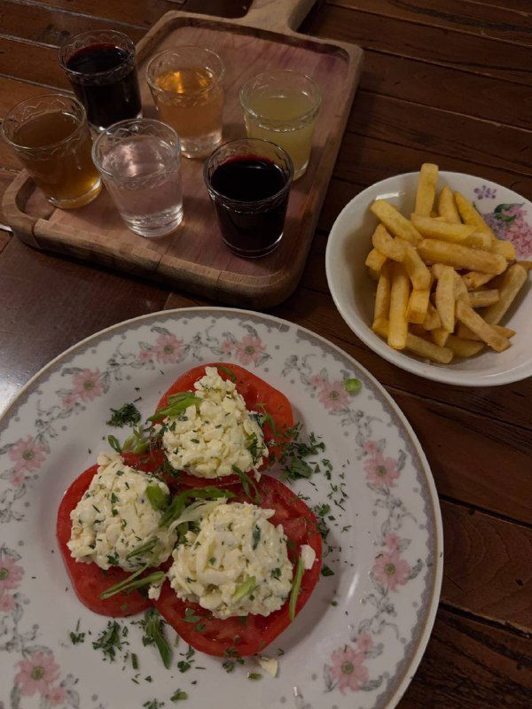 Тарелки с простыми блюдами и картошкой фри на деревянном столе — пример порций и подачи в заведении в ретро-стиле.