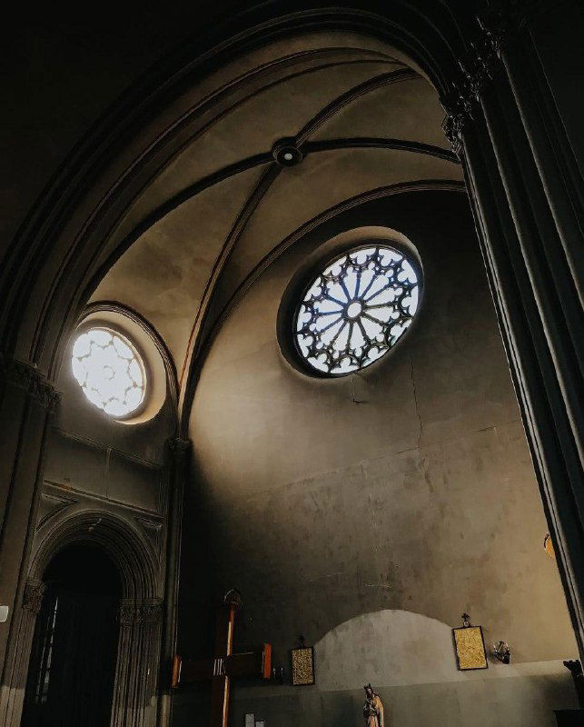 Своды и круглые окошки храма: игра светотени на куполе, простая лепнина и историческая атмосфера интерьера здания.