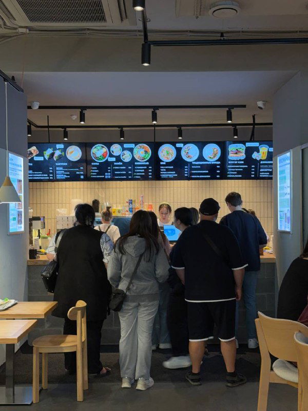 Очередь у кассы и линия раздачи в кафе Кореана Light: цифровое меню и сотрудники за стойкой в стиле корейского стритфуда