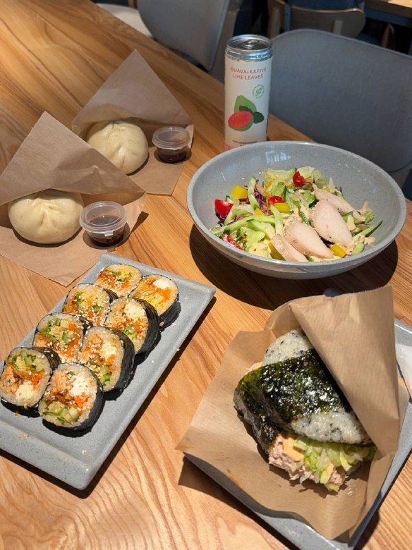 Блюда на столе: кимпаб, булочка на пару и боул с курицей — пример порций и подачи в новом зале Кореана Light на Невском