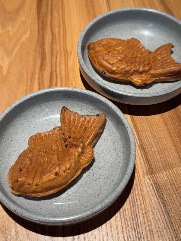 Два тайяки-пирожка на тарелках — десертная подача в Кореана Light, золотистая корочка, подача на матовой керамике на деревянном столе