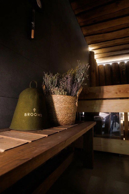 Деревянная парная с полками и вениками, декоративной лавандой и тёплым светом — классическая атмосфера русской бани в комплексе.