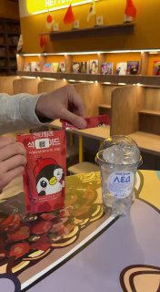 Процесс открытия пакетика с напитком и крышка бутылки с маркировкой, детали сервировки и упаковки напитков в KONO.