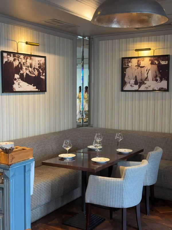 Уютный уголок ресторана с банкетной мягкой зоной, столиками и тёплым освещением — место для небольших компаний.