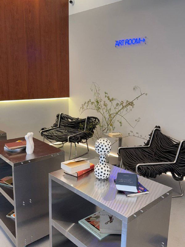Зона отдыха в концепт‑сторе IRNBY: столы с книгами, кресла и арт‑объекты, атмосфера спокойного минимализма и дизайна.