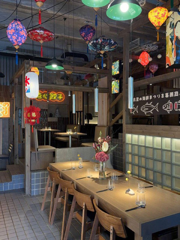 Общий вид зала TAO с подвесными яркими бумажными фонариками, длинными столами и атмосферным мягким освещением внутри ресторана