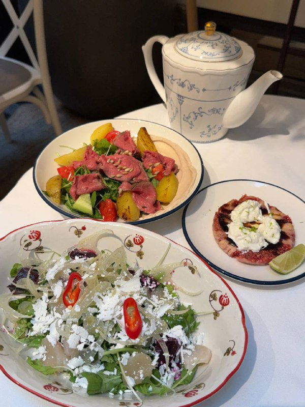 Тарелки с салатами и закусками: ростбиф, салат со свёклой и сезонное карпаччо из инжира — крупный план подачи и сервировки.