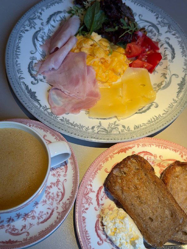 Фирменный завтрак Futurist: тамбовский окорок, сыр, томаты и тартин рядом с чашкой кофе — вид сверху, аккуратная подача.