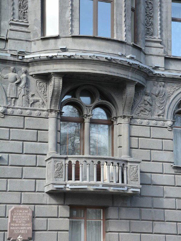 Детальный фрагмент балкона и окна на фасаде дома Роберта Веге: резьба по камню, небольшая балюстрада и рельефная орнаментация вокруг окон.