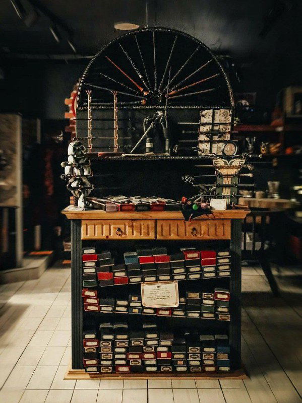 Прилавок магазина-кофейни с полками и декоративными коробками — витрина с сувенирами и товарами в стилистике волшебного мира.