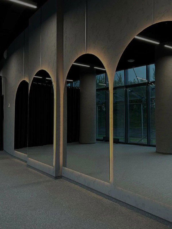 Пустой просторный зал с большими зеркалами и арочными структурами — минималистичный интерьер для занятий йогой, барре или танцами.