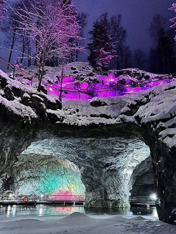 Подсвеченное розовым и фиолетовым мраморное озерцо внутри карьера Рускеала, мост, арки и зимняя атмосфера.