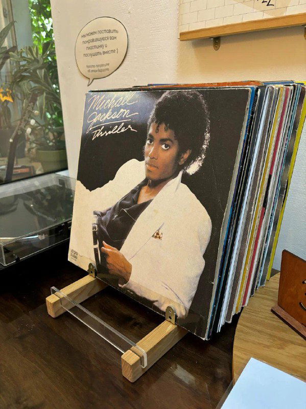 Стойка в магазине с демонстрацией винила: видна обложка Michael Jackson и ряд пластинок в деревянной подставке.