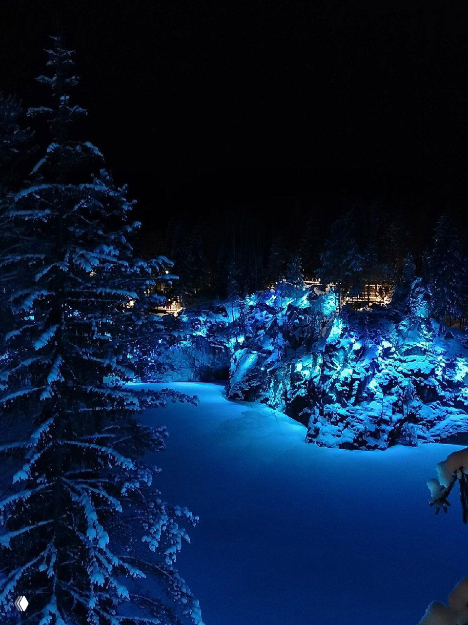 Ночная подсветка горного парка Рускеала: голубые световые акценты на скалах и заснеженных деревьях создают эффект сказочного пейзажа.