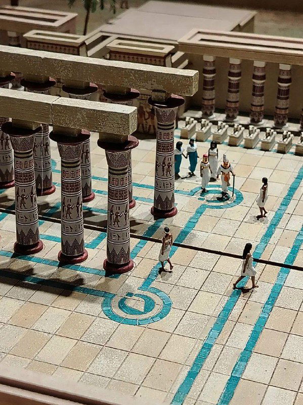 Колоннада древнеегипетского храма в миниатюре: расписные колонны, выложенная плитка и маленькие фигурки для масштаба экспозиции в музее.