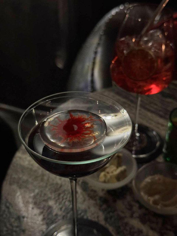 Крупный план коктейля с фрактальной декоративной подачей — Saint poison с нотами ладана, сервированный на мраморной поверхности бара Infuse.