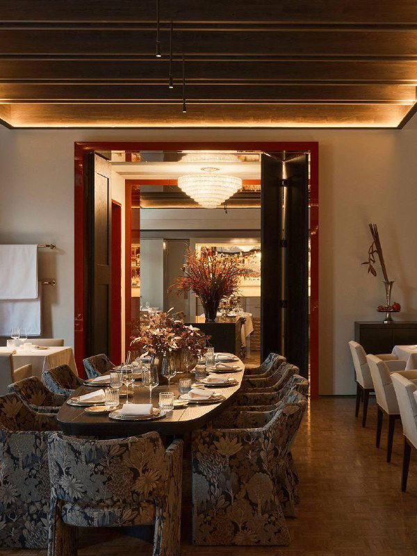 Элегантный зал ресторана с хрустальной люстрой, большим круглым столом и нейтральной цветовой гаммой, интерьер в стиле fine dining.