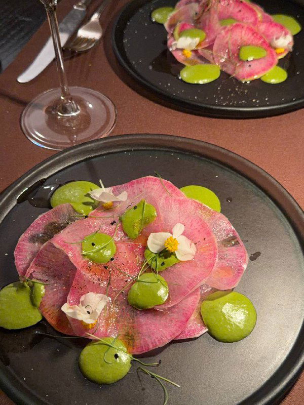 Тонко нарезанное мясо или карпаччо на тарелке с зелёными кремовыми точками и микрозеленью — эстетичная холодная закуска из сета 83