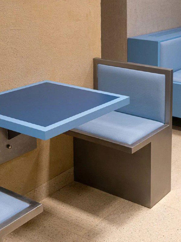 Зона посадки в BUMO: угловые сидения и голубые столы в лаконичном стиле, простая отделка и аккуратная мебель.