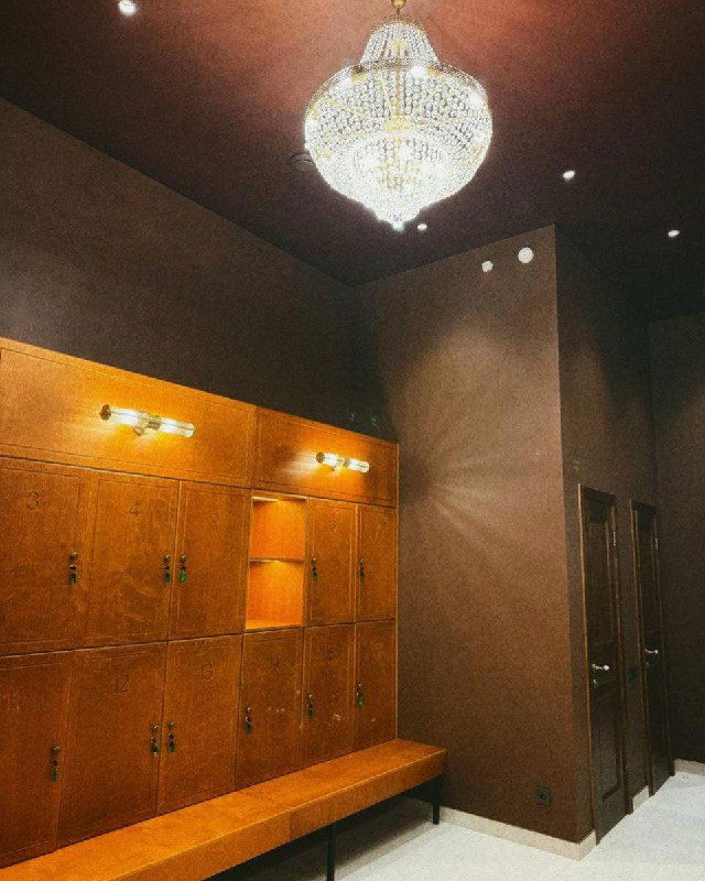 Раздевалка и зона хранения клуба «Ракета»: деревянные скамьи и шкафчики в тёплой отделке, приглушённое освещение и аккуратный интерьер для игроков.