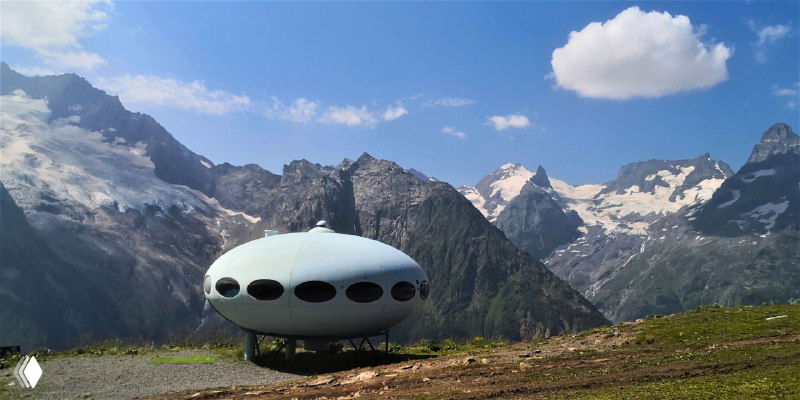 Необычное сооружение в форме летающей тарелки на склоне Мусса-Ачитары: небольшой дизайнерский отель на фоне горных пиков.