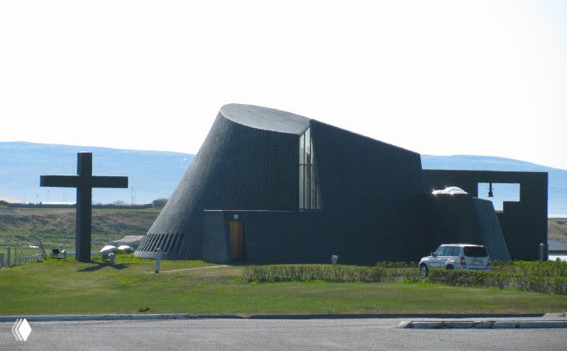 Необычная современная церковь новаторской формы на северном побережье Исландии: минималистические линии и чёткие геометрические формы в ландшафте.