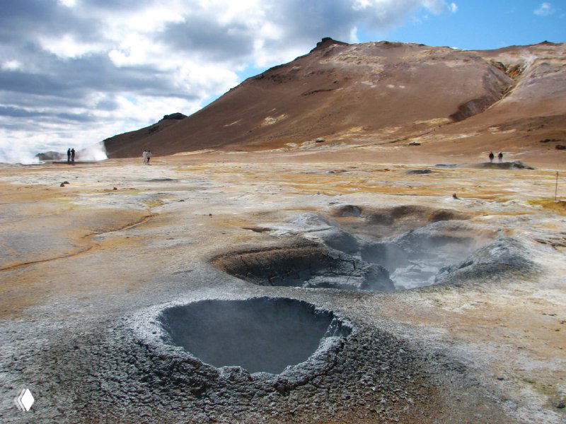 Термальная зона Намаскард: грунт с выпавшими пятнами, паровые отверстия и кипящие котлы, видны кратеры с горячей грязью и парящие струи.