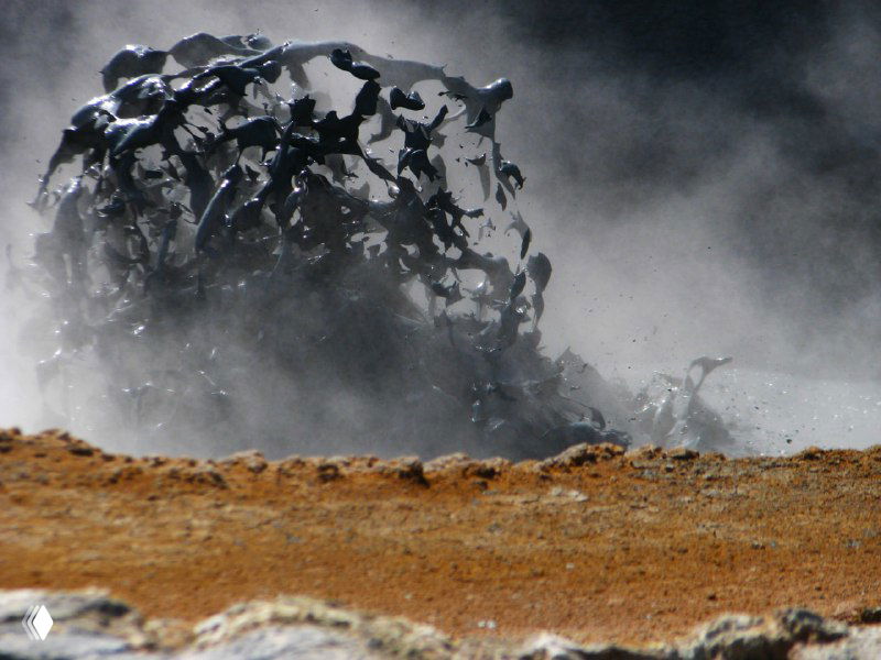 Кипящая грязевая масса вблизи: брызги и пузырение горячей глины, деталь активности грязевых вулканчиков в геотермальной зоне.