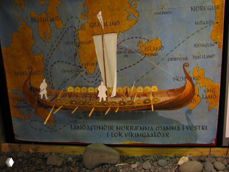 Иллюстрация и музейная витрина с изображением викингского корабля и морских маршрутов — историческая экспозиция о мореплавании и саговом наследии.
