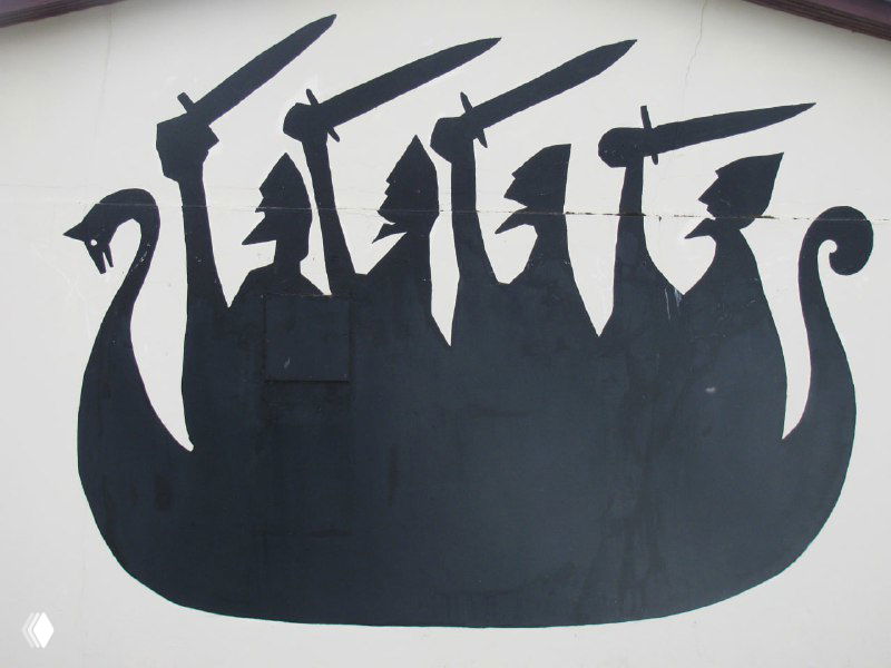 Графическая чёрная вывеска с силуэтами викингов и оружием на светлом фоне — декоративный мотив на фасаде или в музее, отображающий образ викингов.