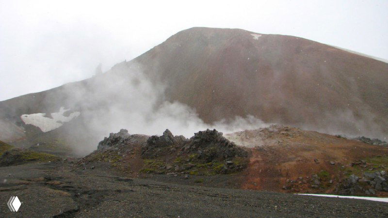 Горячие пары над раскалённой почвой и красные оттенки риолитового холма, вид близко к источникам горячей воды.