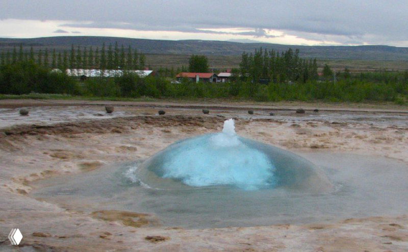 Малый голубой пузырь в кипящей лужице гейзера перед вспышкой — момент перед извержением Строккура, вид на площадке гейзеров.