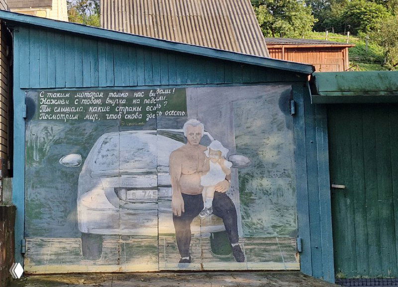 Фреска на гаражной стене: мужчина с ребёнком сидят на фоне автомобиля, выполнено в приглушённых натуральных тонах в Боровске