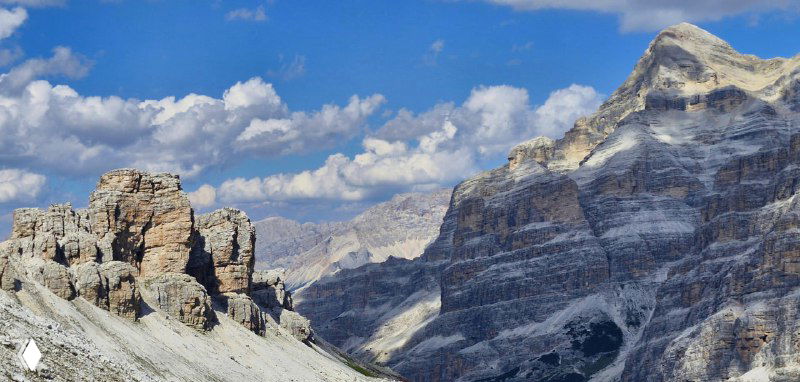 Крупный план резких уступов и текстуры скал Доломитов, подчёркивающий геологические формы и контрасты с небом.