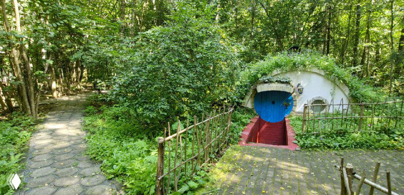 Хоббитские норки в лесной зоне эко-отеля: круглые окна и низкие входы среди деревьев и мшистых дорожек в Подмосковье.