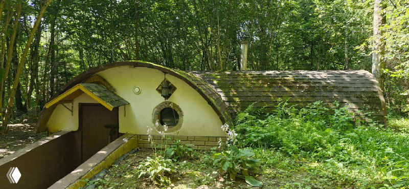 Хоббитский домик с зелёной небольшой веранды и круглыми окнами, вросший в землю и покрытый растительностью — типичный образ в Подмосковье.