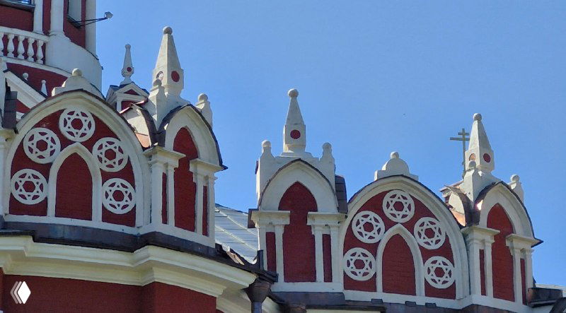 Декоративные архитектурные детали красочно отделанной церкви: арки, орнаменты и элементы кровли вблизи, показывающие мастерство декора.